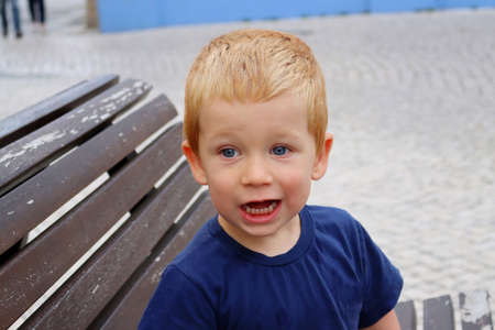 Portrait of a charming blond boy. A three year old boy smiles with his mouth wide open. Happy child.の写真素材