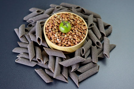 Penne rigate pasta made from buckwheat flour. Penne rigate pasta on a gray background.