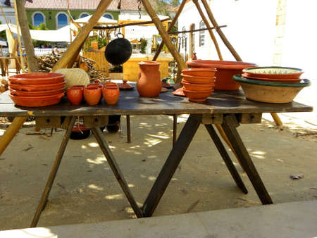 Ceramic plates, bowls and a jug on a wooden table. Handmade ceramics.の写真素材