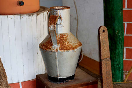 Old rusty metal water jug. Vintage kitchen utensils.の写真素材