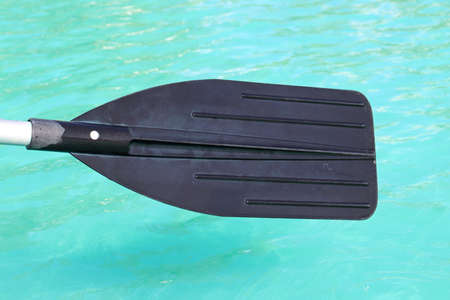 Image of a part of a paddle from a rubber boat against a background of blue water.の写真素材