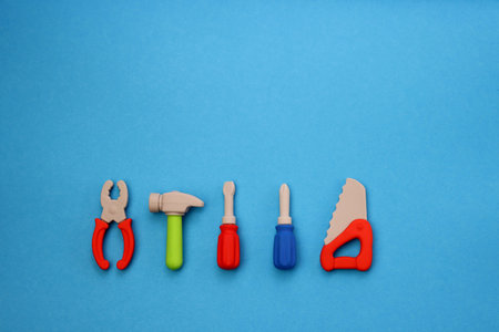 Children's mini versions of screwdrivers, saws, hammer and pliers on a blue background. Children's toolsetの写真素材