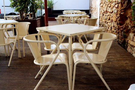 Metal tables and chairs in a street cafe. Beige tables and chairs.の写真素材