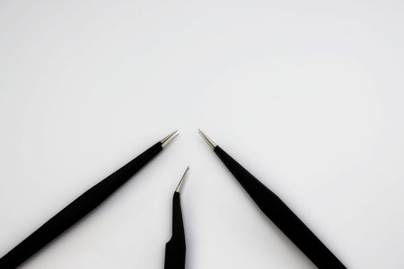Three black anti-static tweezers isolated on white background