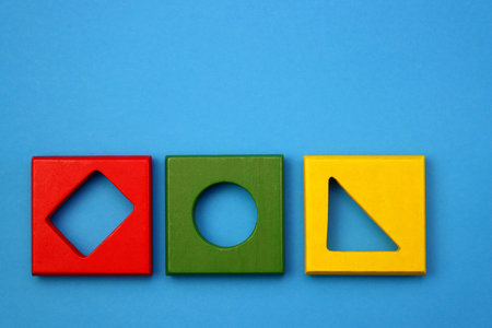 Colorful Children's wooden toy. Sorter of a cube shape on a blue background. Children's brain...