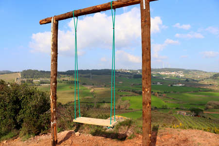 Homemade empty rope swing against the backdrop of the picturesque nature of Portugal.の写真素材