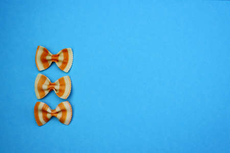 White-orange farfalle paste on a blue background.の写真素材