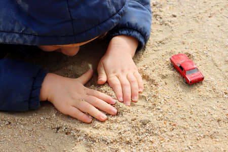 Child's hands are playing with sand. Small baby palms close up.の写真素材
