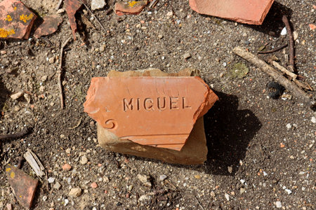 Part of a red roof tile with the male name Miguel inscribed in Spanish.の写真素材