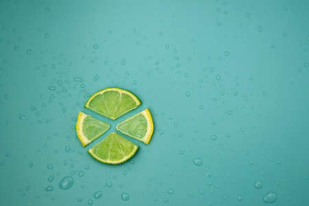 Slices of fresh lime and lemon on a blue background with water drops. Citrus background.の写真素材