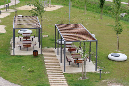 Torres Vedras, Portugal - May 2021: Recreation area in a green park with wooden tables, benches and exercise equipment for sports.のeditorial素材
