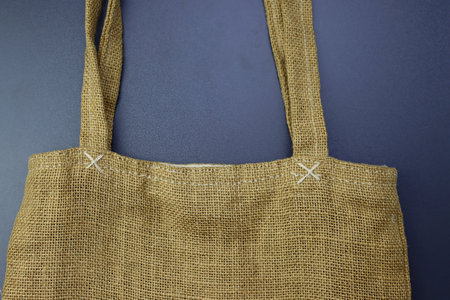 Part of a bag made of Hessian fabric on a gray background. Women's bag made of burlap.の写真素材