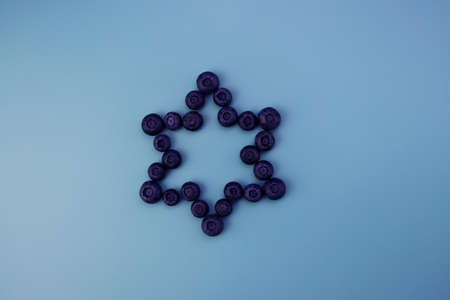 Blueberries are laid out in a star shape. Fresh ripe blueberries on a blue background.の写真素材