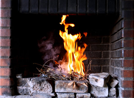 Fire and smoke in the fireplace. The branches are burning. Open fire, burning wood