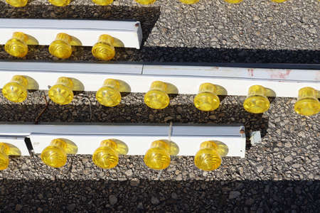 Illumination from a variety of yellow LED lamps. Small yellow light bulbs attached to a metal panel.の写真素材