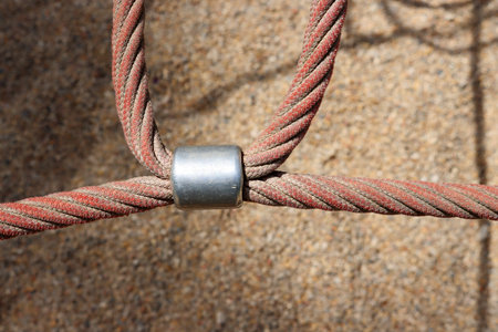 Reinforced rope and metal connectors. Fragment of a rope pyramid in the playground.