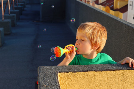 Blond boy makes soap bubbles. A four-year-old boy plays with soap bubbles.の写真素材