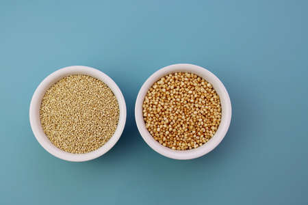 Grains of quinoa and quinoa popcorn in white round bowls on a blue background.の写真素材