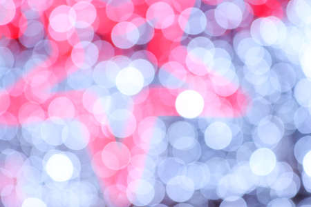 Bokeh on Christmas night. Natural bokeh outdoors in red and white tones. Blurred background with Christmas illumination. Festive background for New Year Merry Christmas.の写真素材