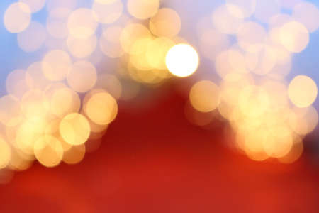 Bokeh on Christmas night. Natural bokeh outdoors in yellow and red tones. Blurred background with Christmas illumination. Festive background for New Year Merry Christmas.の写真素材