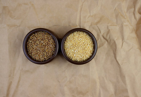 Dark and light bulgur in round bowls on a background of crumpled paper.の写真素材
