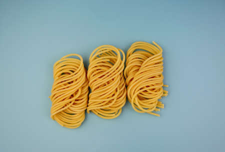 Durum wheat pasta is beautifully rolled into a skein. Matassa Pasta on a blue background.の写真素材
