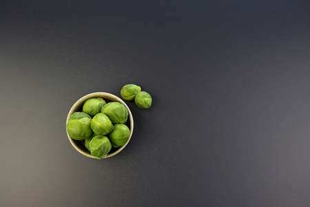 Fresh Brussels sprouts in a round bowl on a gray background.の写真素材