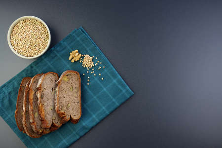 Buckwheat bread with walnuts. Pieces of bread and green buckwheat on a blue towel. Vegan baking.の写真素材