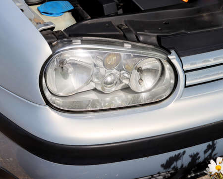 Car headlights and open hood. Exterior detail close-up. Details of an old carの写真素材