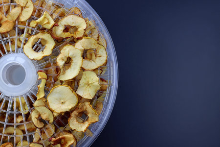 Sliced pieces of apples on round wire racks for drying. Drying apples in a dehydrator.の写真素材