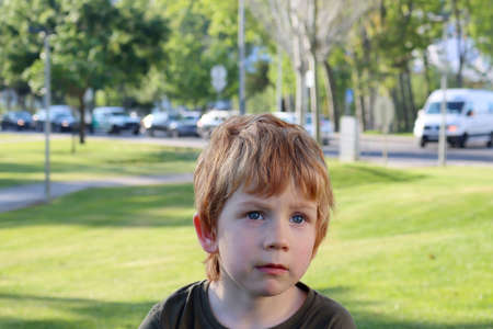 The blond boy looks into the distance with interest. A five year old boy with a puzzled look.の写真素材