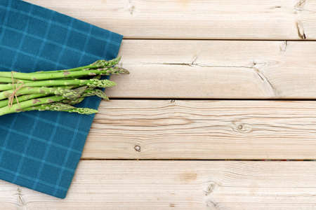 Green asparagus on a wooden background. Fresh young asparagus pods.の写真素材
