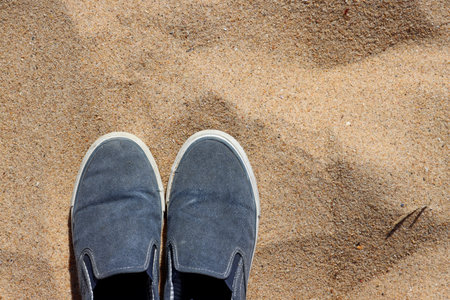 Men's fabric slip-ons in the sand background. lightweight shoes without laces