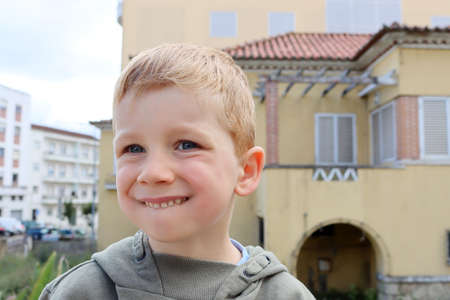 The blond boy bit his lower lip and squinted his eyes. A five-year-old boy made a grimace.の写真素材