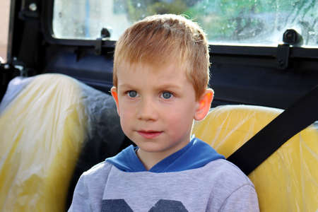 The blond boy is looking into the distance with concentration. A tense five-year-old boy.の写真素材