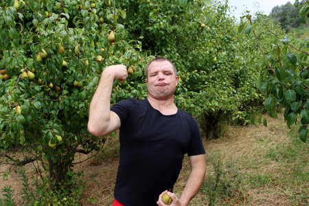 The bristly man pouted his lips and showed his biceps. A forty-year-old man fools around and makes faces.の写真素材