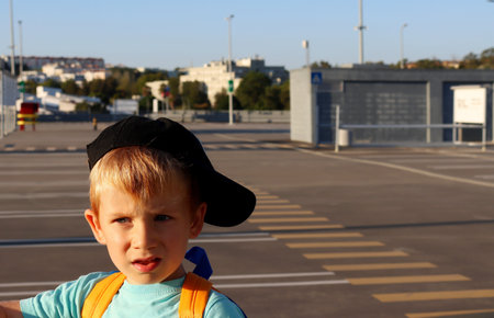 A blond boy with frowning eyebrows and ajar mouth. A five-year-old boy looks seriously into the distance.の写真素材