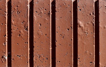 Image of a brown stone wall with vertical stripes. An old wall with irregularities and roughness.の写真素材