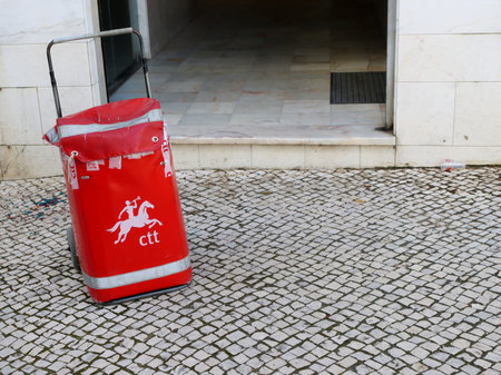 Torres Vedras, Portugal - February 2023: Red bag on wheels. Old postman's bag.のeditorial素材