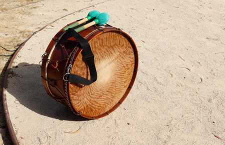 Close-up of a wooden drum and beaters on the sand. Music concept photography.の写真素材
