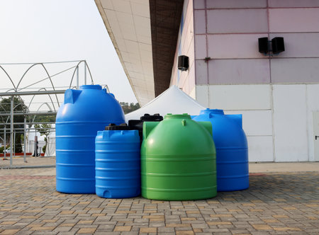 Green and blue barrels for agriculture. Plastic containers for storing water and fertilizers.の写真素材