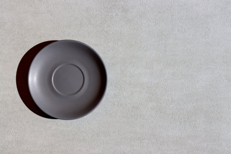 Top view of empty gray ceramic plate on concrete background with copy spaceの写真素材