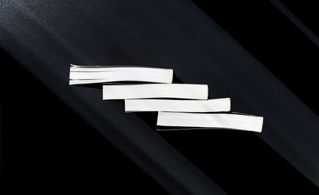 Four white books on a black background. View from above. Copy space.の写真素材