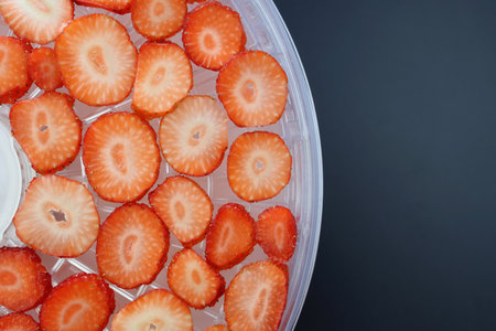 Thinly sliced strawberries on round drying racks. Drying strawberries in a dehydrator.の写真素材