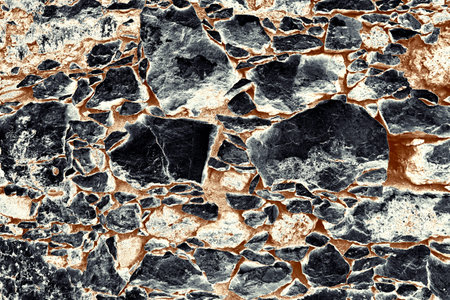 Grunge abstract texture of old stone wall with black, white, and rusty brown colors ideal for...