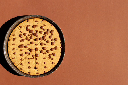 Pizza Cookies. Round cookie pie with chocolate chips arranged in geometric slices on a brown...
