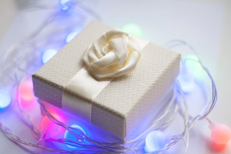 White gift box with bow and garland