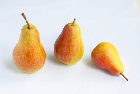 Three ripe red and yellow pears isolated on a white background