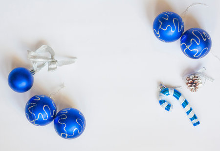 Christmas flat lay blue Christmas balls with silver pattern, candy cane and cone silver gift box on...