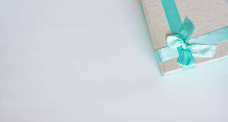Silver gift box with bright blue bow flat lay copy spaceの写真素材